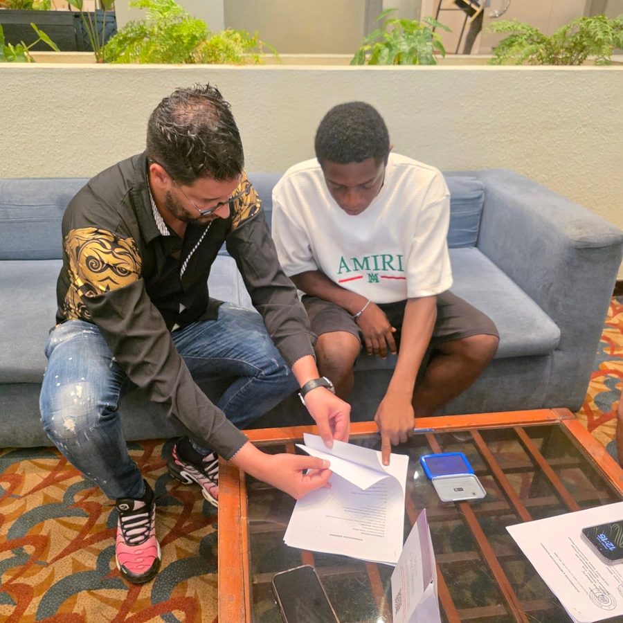 Abdou Younes going through a document with a young player